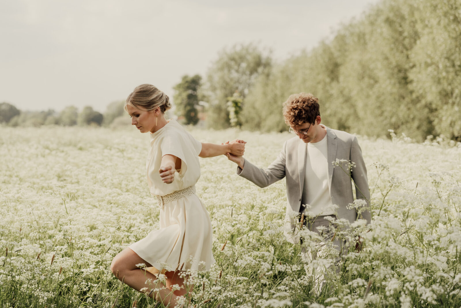 huwelijksfotografie spontaan in de bloemen wandelen man en vrouw