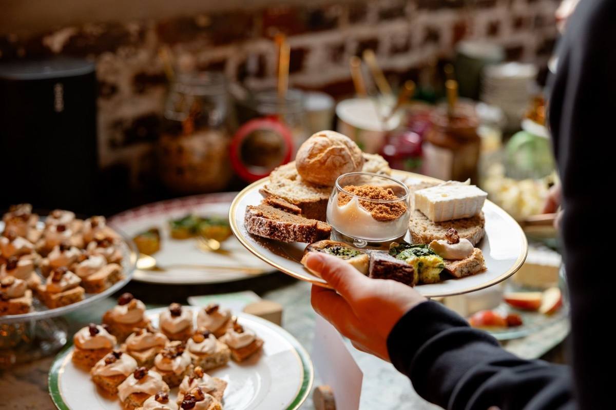 Een bord met brood, kaas, hartige hapjes en een speculaasdessertje