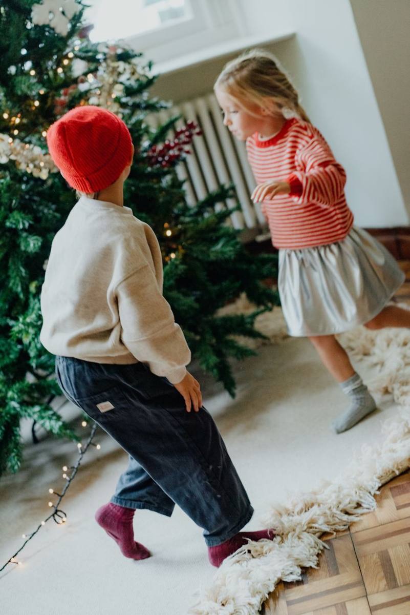 Twee kinderen dansen bij de kerstboom