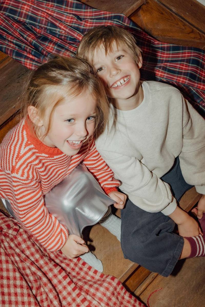 Broer en zus lachen op een geruite plaid